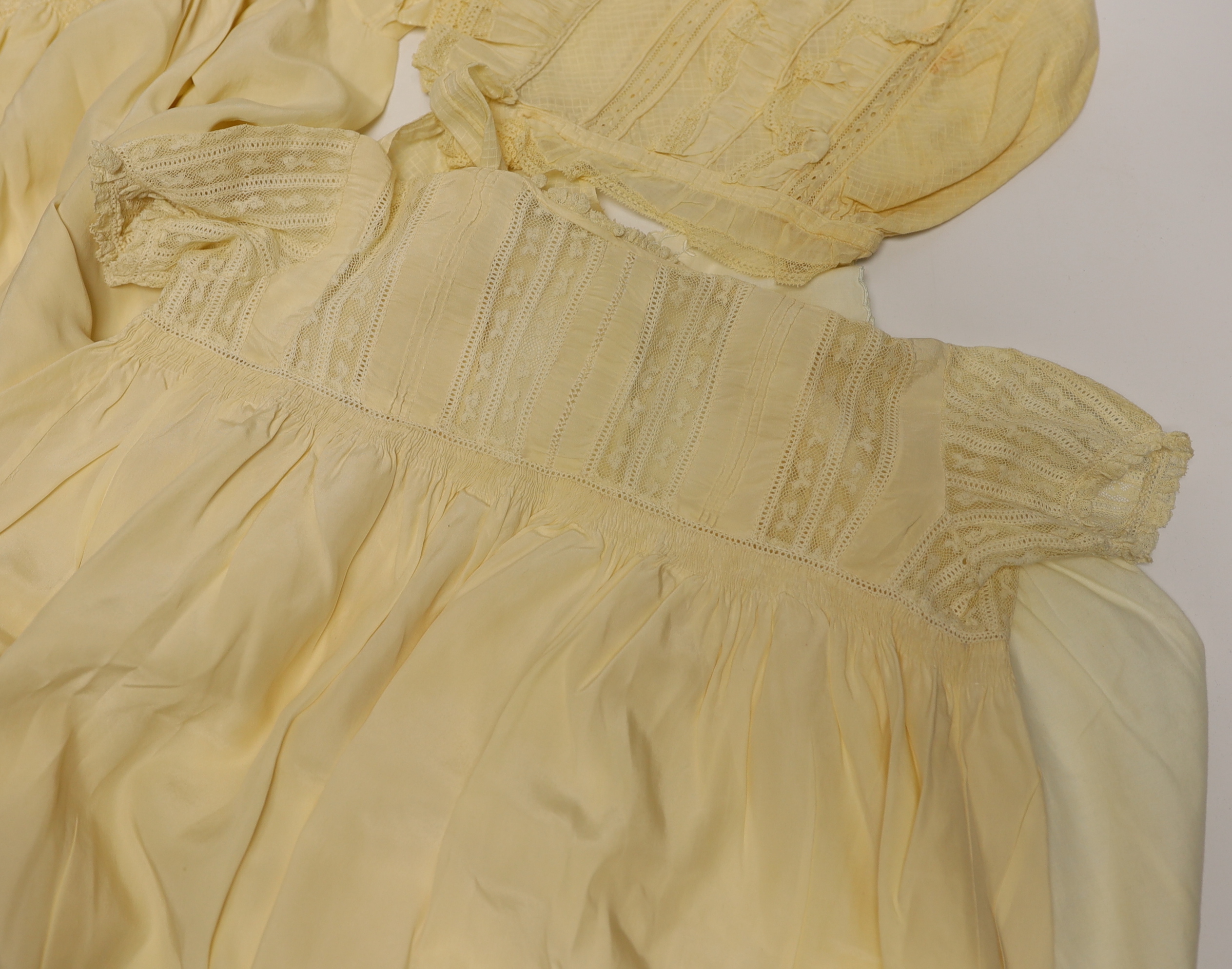 Two 19th century silk baby gowns, a ladies lace trimmed bonnet, a black satin and lace maids apron, various tatting tape lace and other table mats, etc.